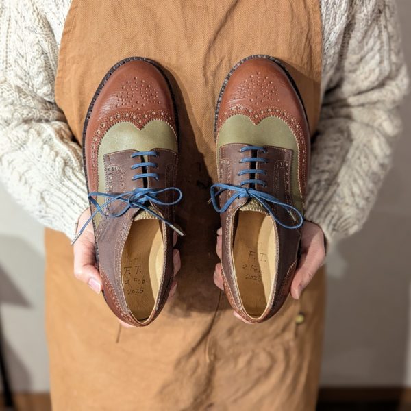 完成した靴を手に記念写真