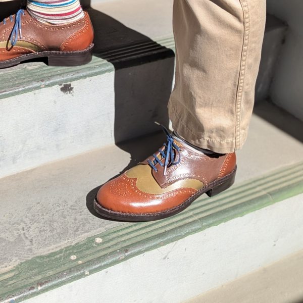 完成した靴を履いた左側の写真、手縫い後の装飾のコテで縫い目も美しく浮き立っています