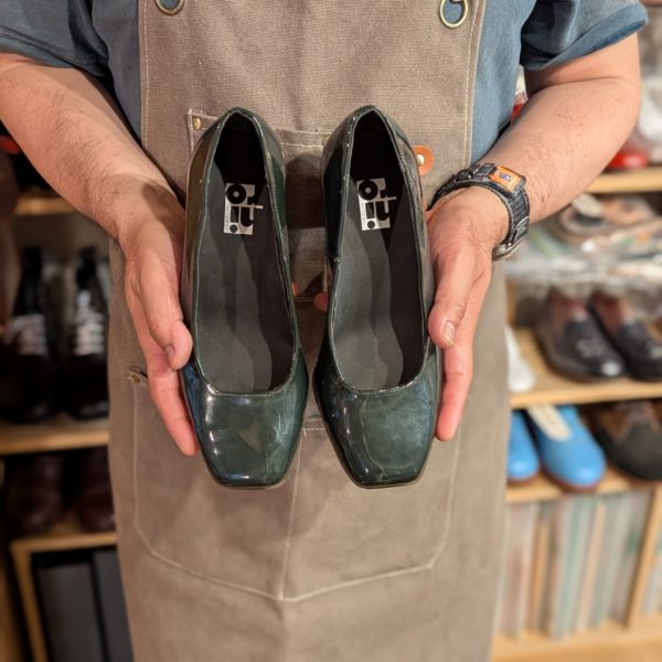 シューマスターコースの生徒さんが完成したエナメルパンプスを手に持った写真