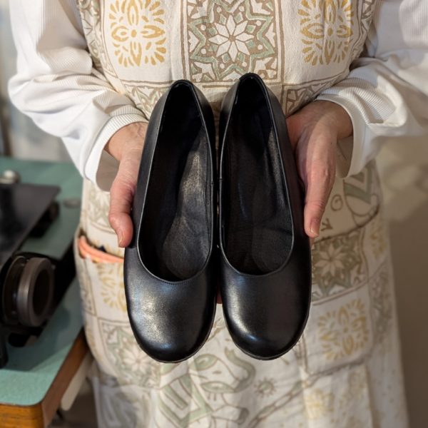 初めての靴づくりで完成したパンプスを手に正面写真