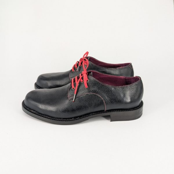 紫の裏地とオリジナルの金具が光る手作り革靴の左側面