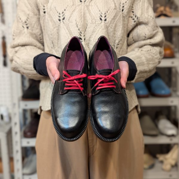 完成した手作り靴を手に持った正面写真