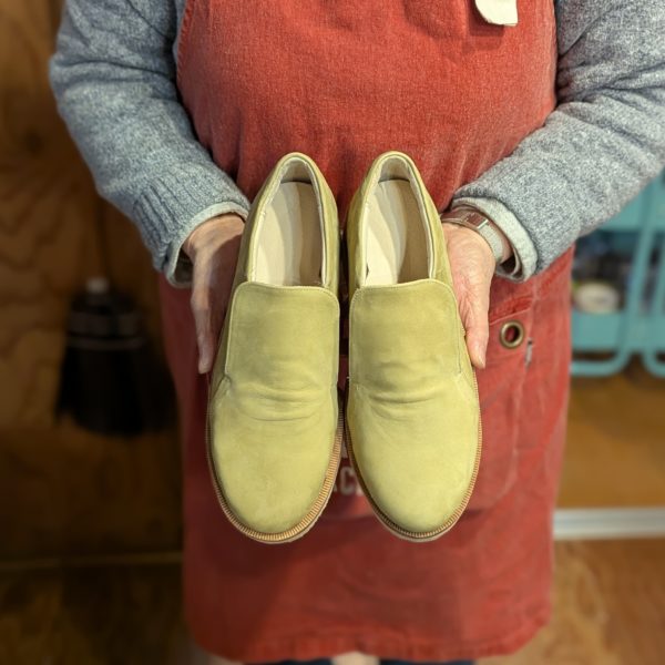 手作りシューズのスリッポンを手に持つUさんの完成写真