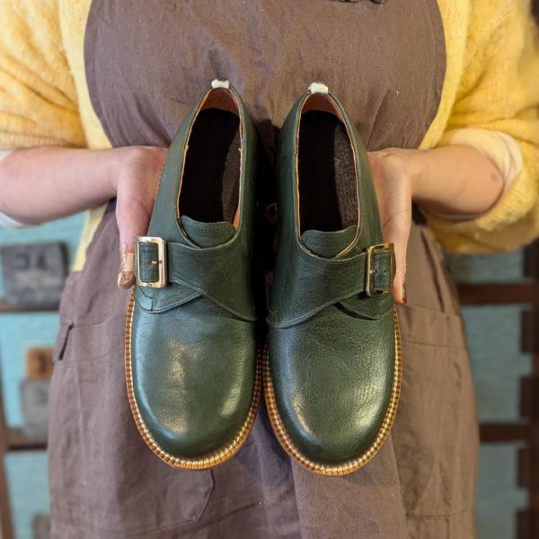 大人の習い事で制作したグリーンのモンクストラップ靴を持つFさん